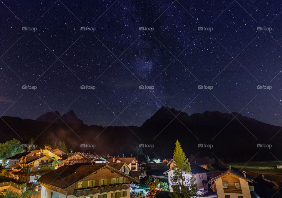 Small village in the mointains with milky way sky and many stars