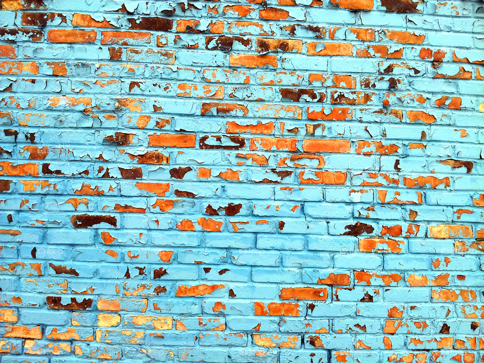 Blue brick wall with its paint chipping off