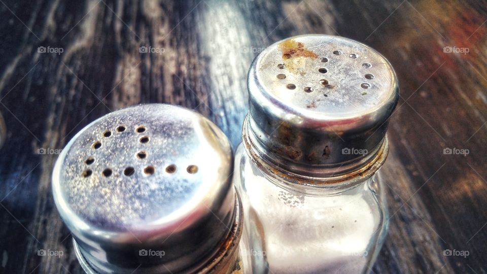 Pepper and salt shaker containers on a table.