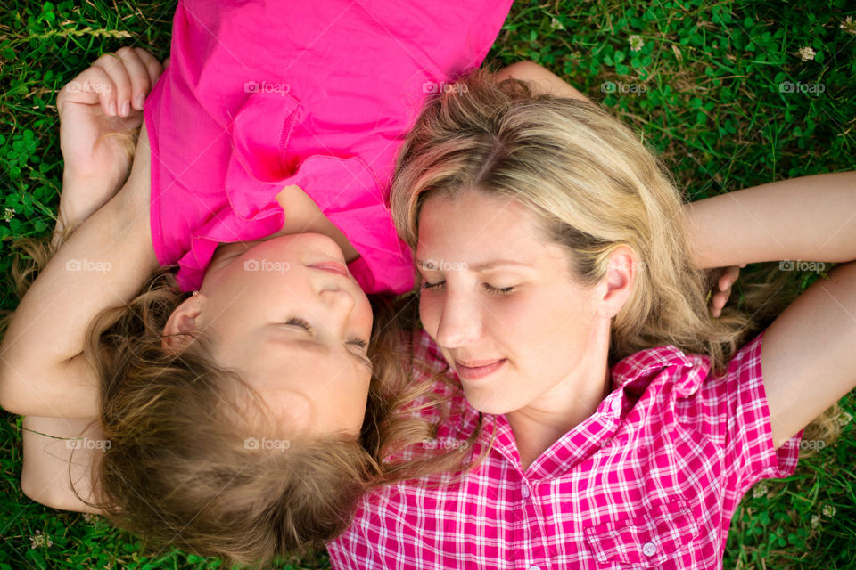 High angle view of mother and daughter lying on grass