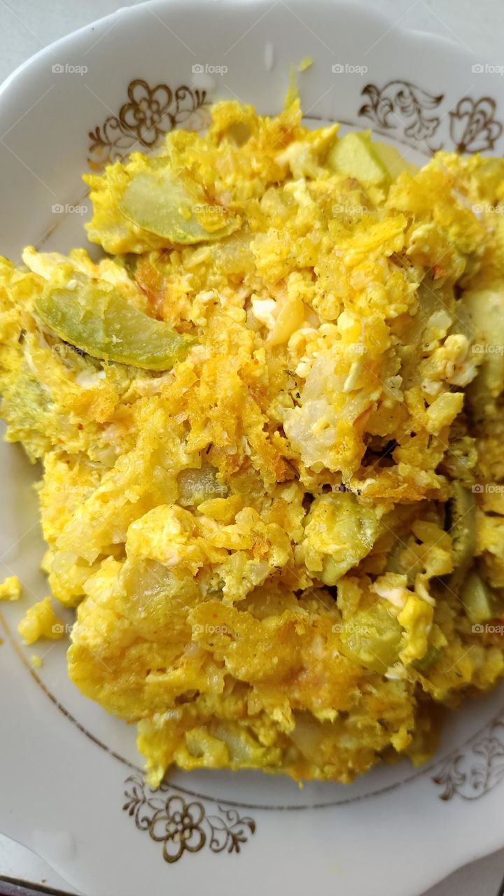 Delicious breakfast - stewed zucchini with rice and egg and a little turmeric