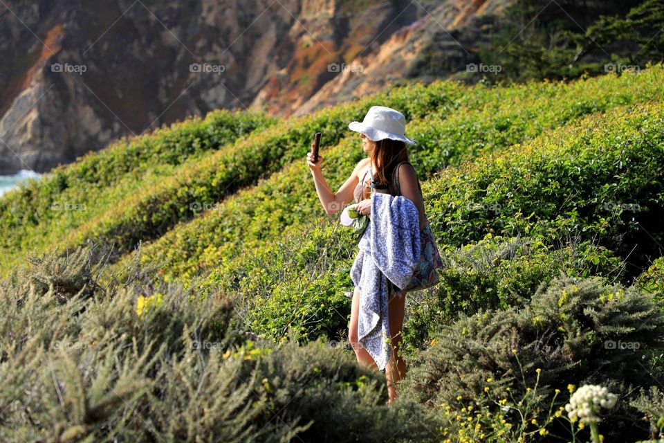 Lady taking photo on mountain