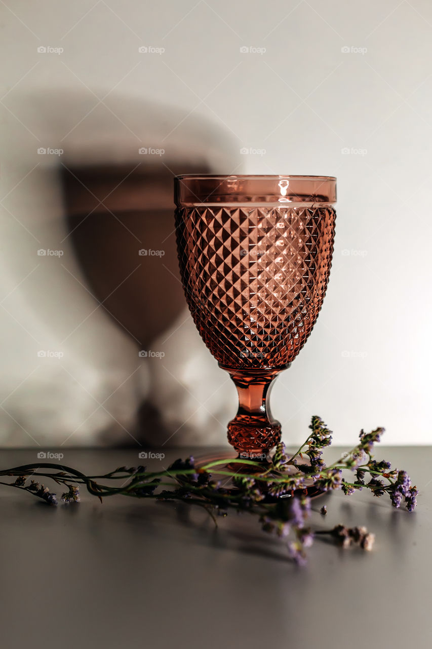 Wineglass with shadow and dry flowers