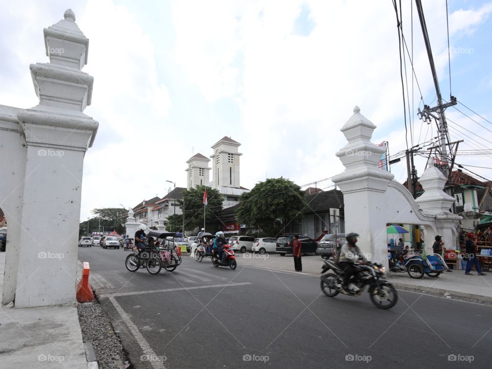 Mopeds and rickshaws pass through the gates marking the northern end of the Sultan's Palace complex in Yogyakarta, Indonesia.