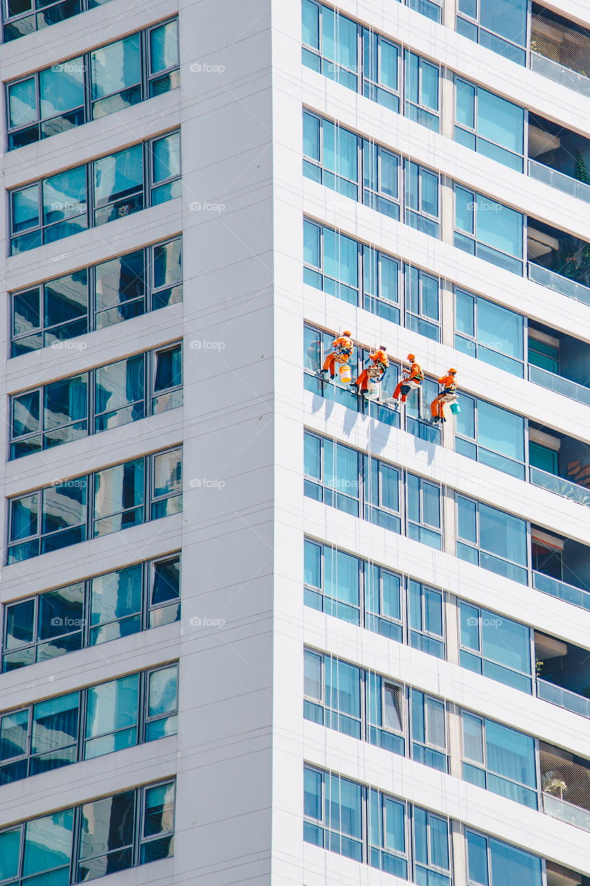 Workers cleaning windows on a building 