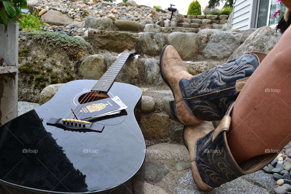 Cowgirl on steps with guitar and passport