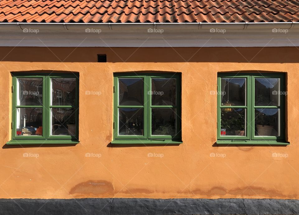 Orange rustic house with green windows