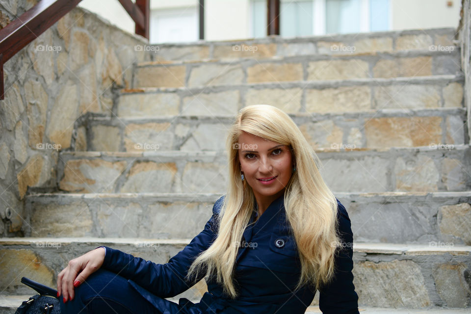 Young woman sitting on stone staircase