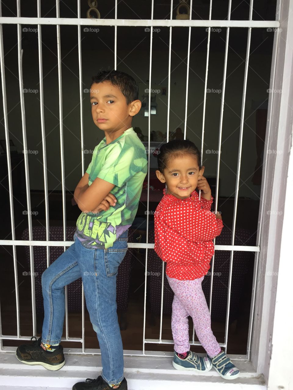 Brother and sister standing near window