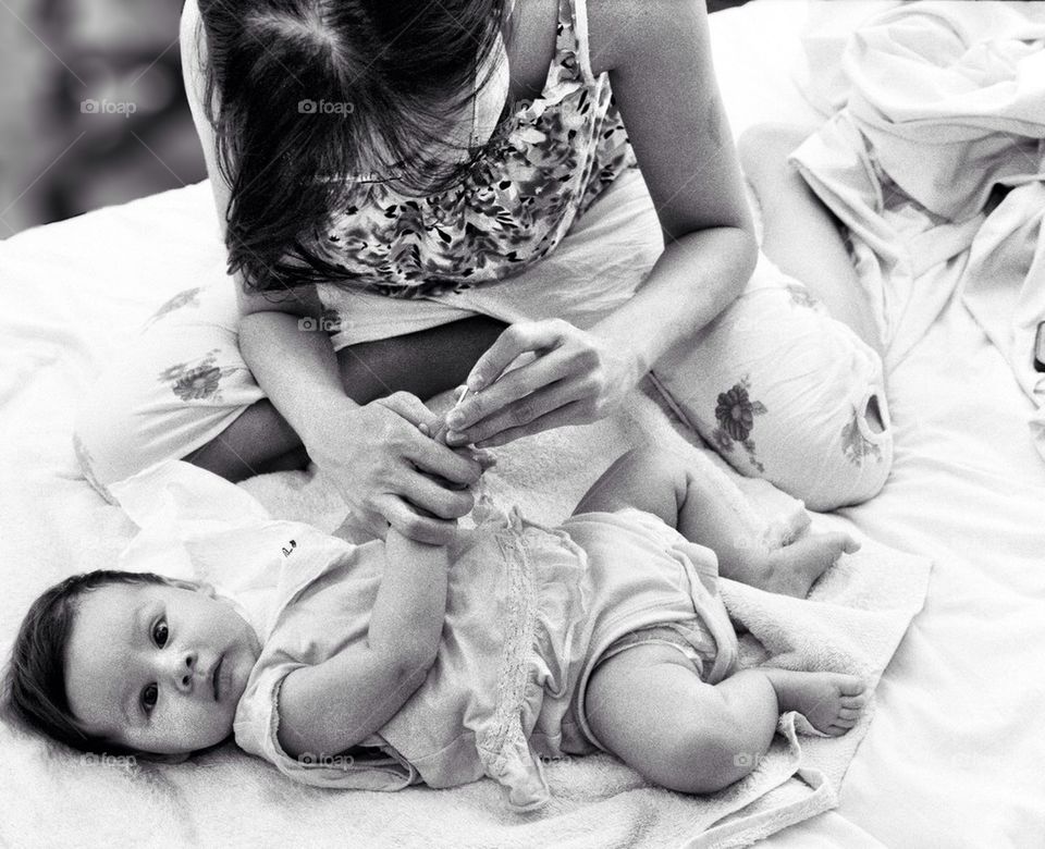 Mum cutting baby's fingers nails