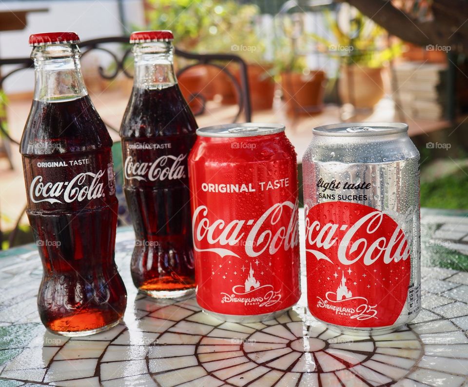 Coca Cola bottles on garden table.