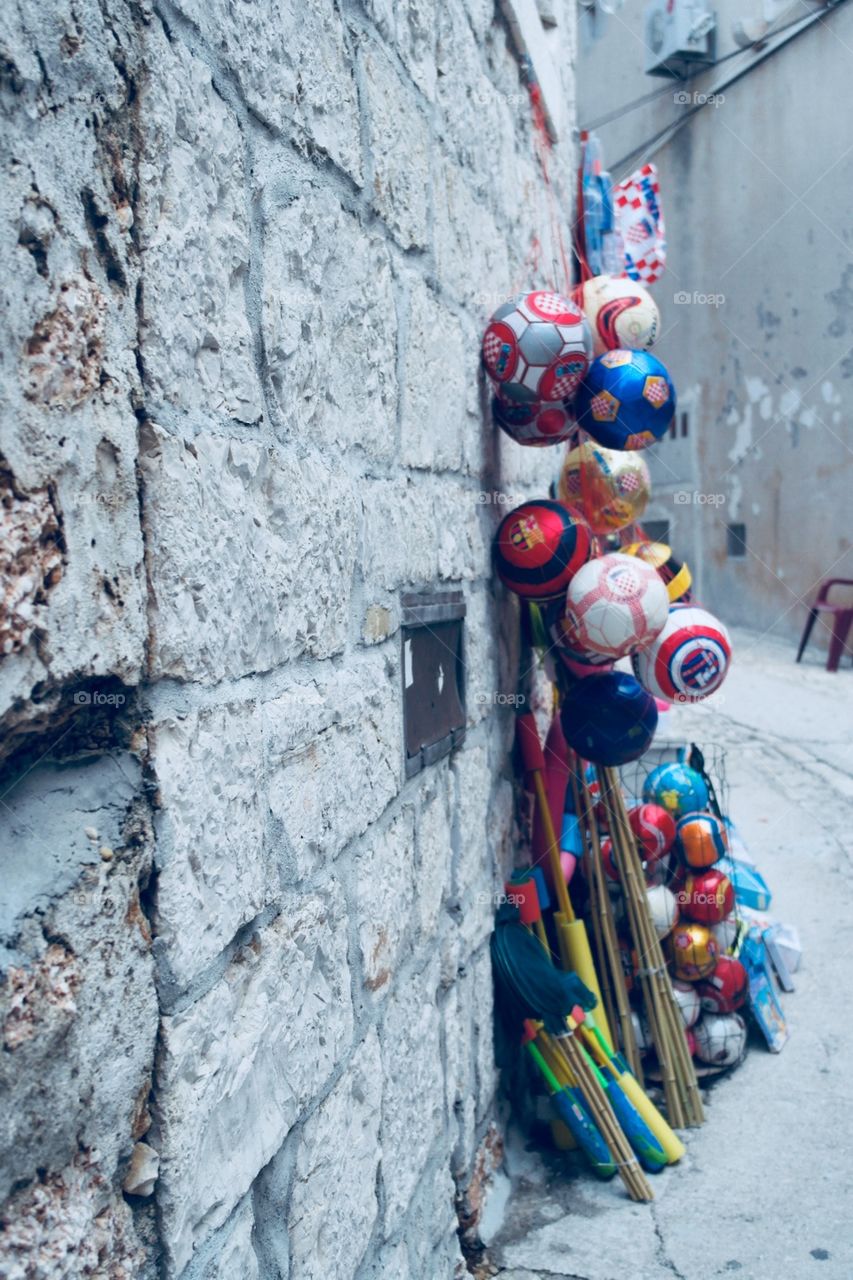 Footballs for sale in the streets of Croatia and a Stony wall