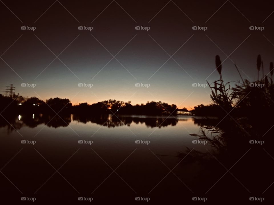 Spring 2019 silhouette of the Lake Water Flat Calm. Beautiful Green Twilight atmosphere playing tricks on us this day. 