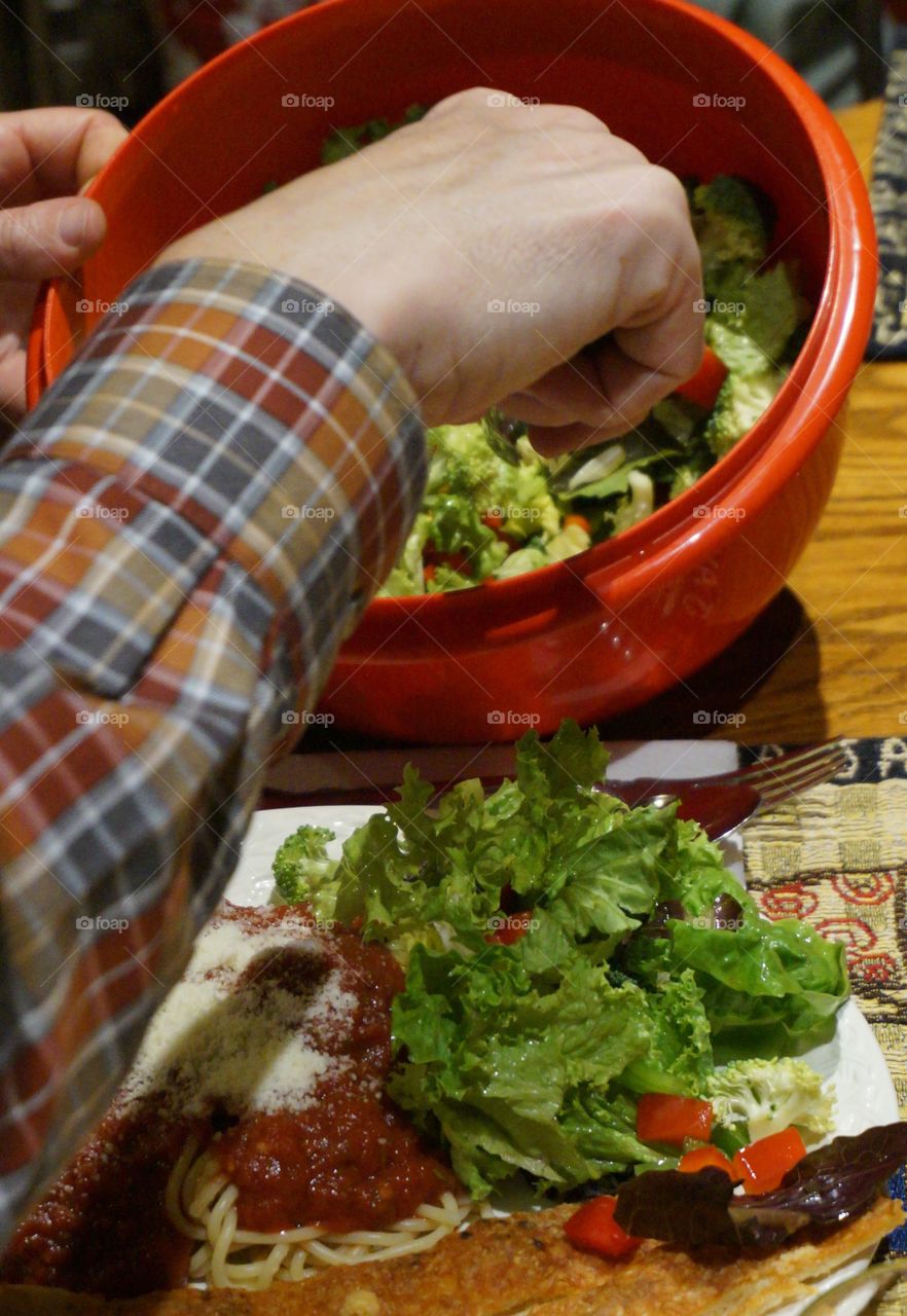 Man filling his plate with salad
