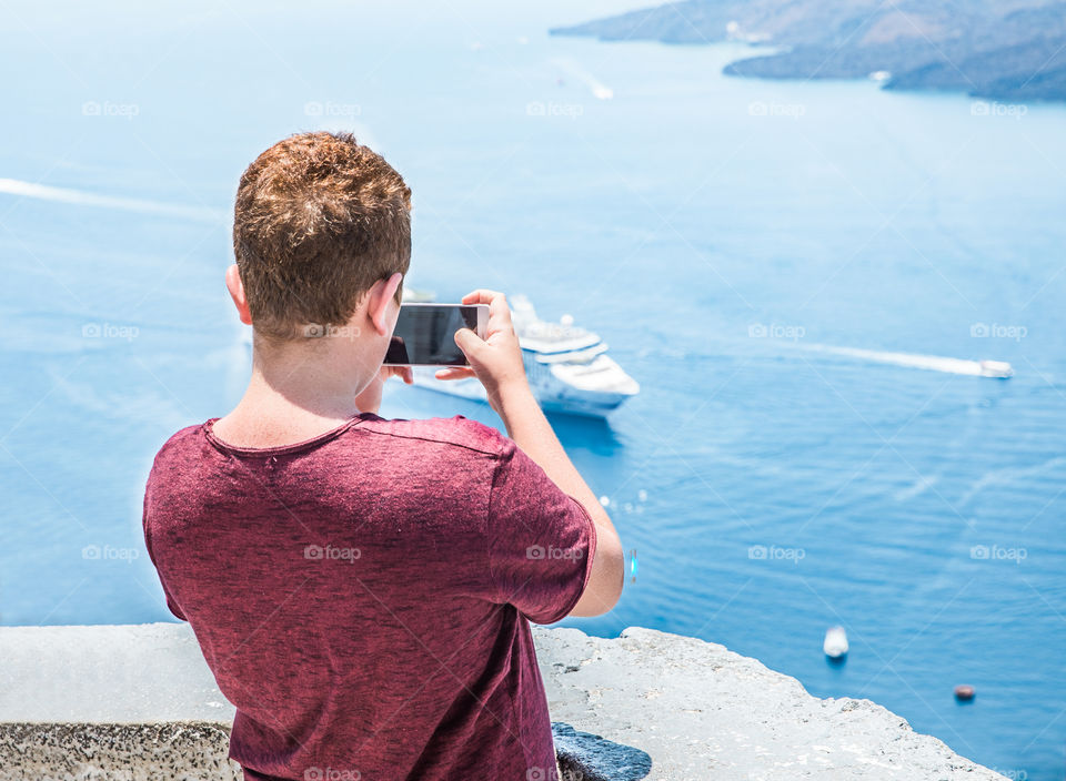 Tourist Boy Taking Photo With Smartphone In Famous Greek Island Santorini