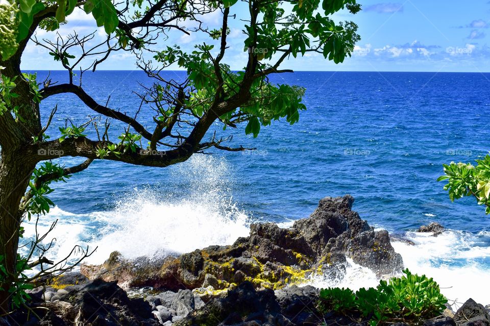 An ocean wave meets lava rock on Hawaii island