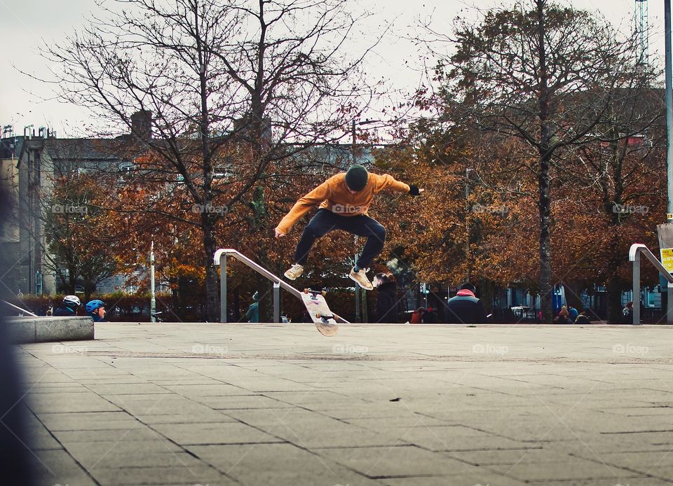 Skater doing trick on Eyre square in Galway city, Ireland