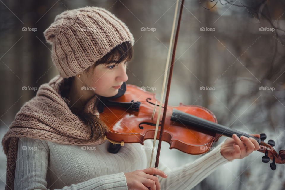 Teenage girl portrait with violin in winter park