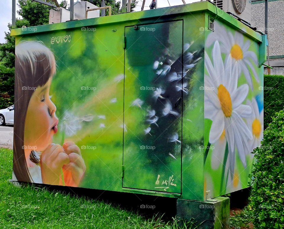 Niña soplando diente de león.