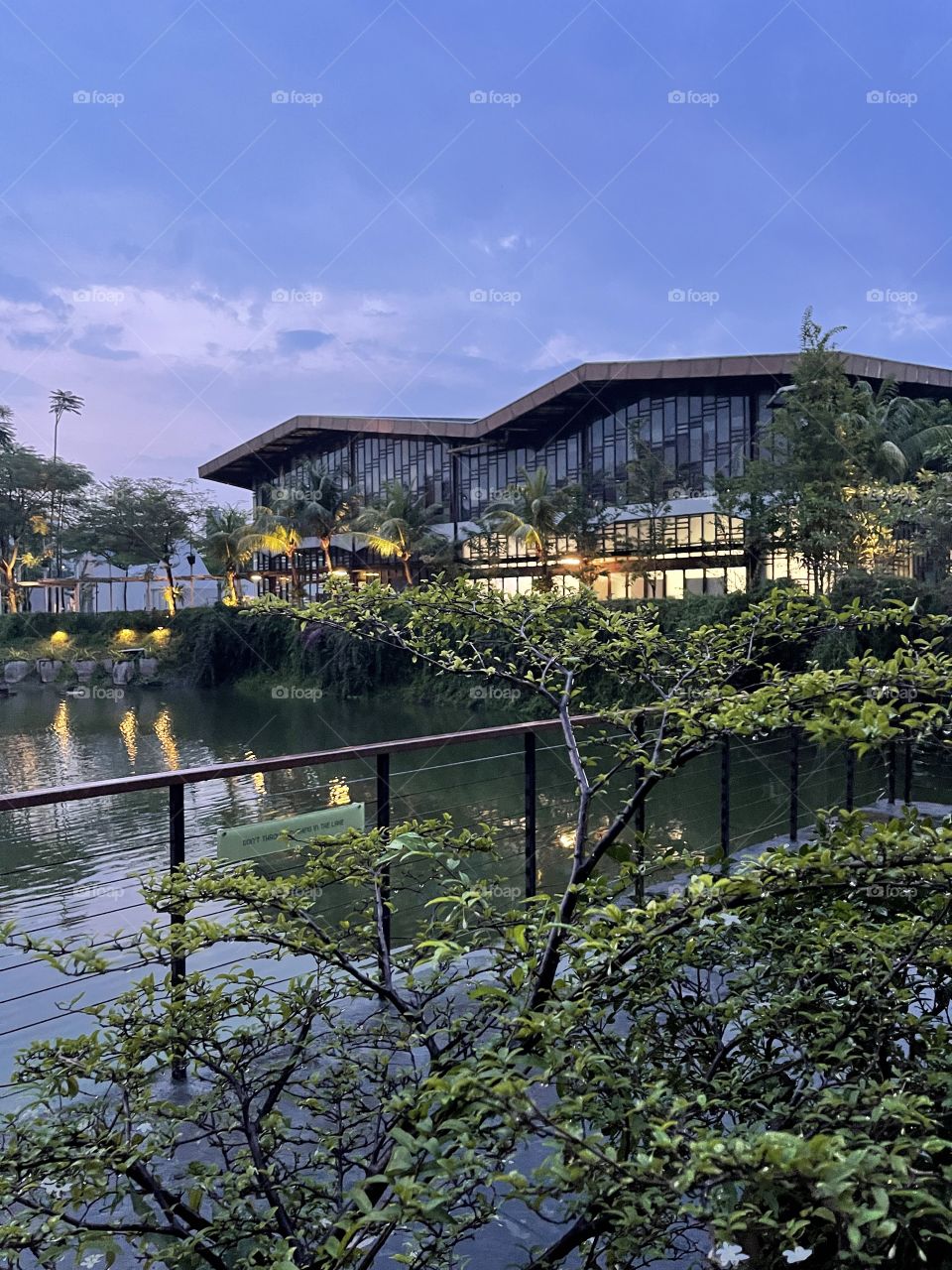 Building across lakeside with reflections, shoot before dark