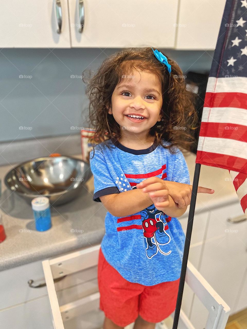 Toddler girl with American flag, toddler girl wearing Mickey Mouse patriotic shirt, making patriotic brownies, desserts for Independence Day, little girl celebrates the Fourth of July 