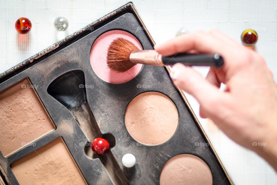 Woman is using a powder makeup set