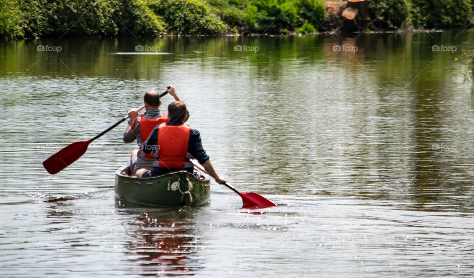 friends paddling up river in kayak