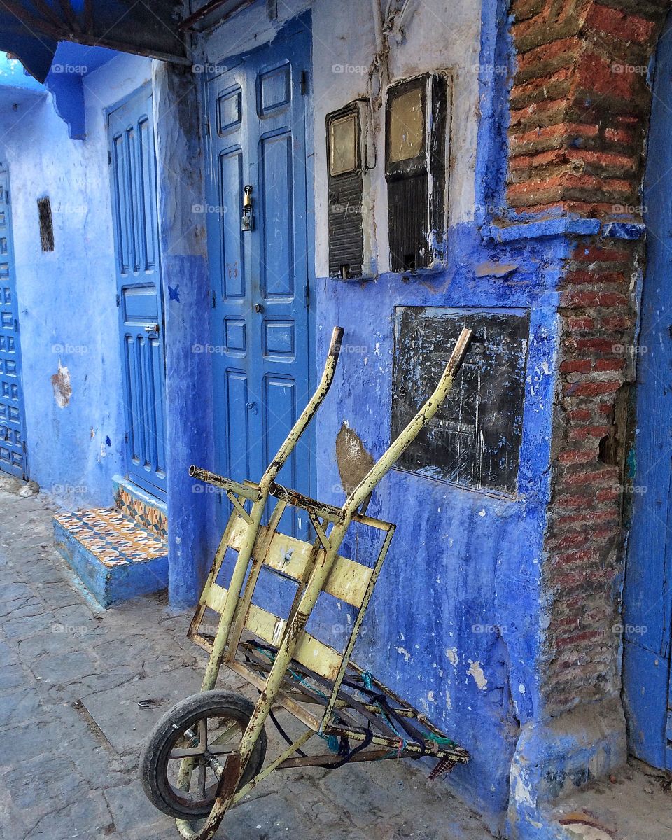 Wheelbarrow against blue wall