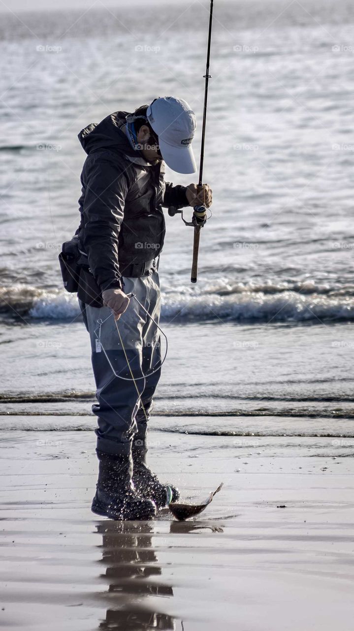 fisherman catches a fish at the edge of the coast