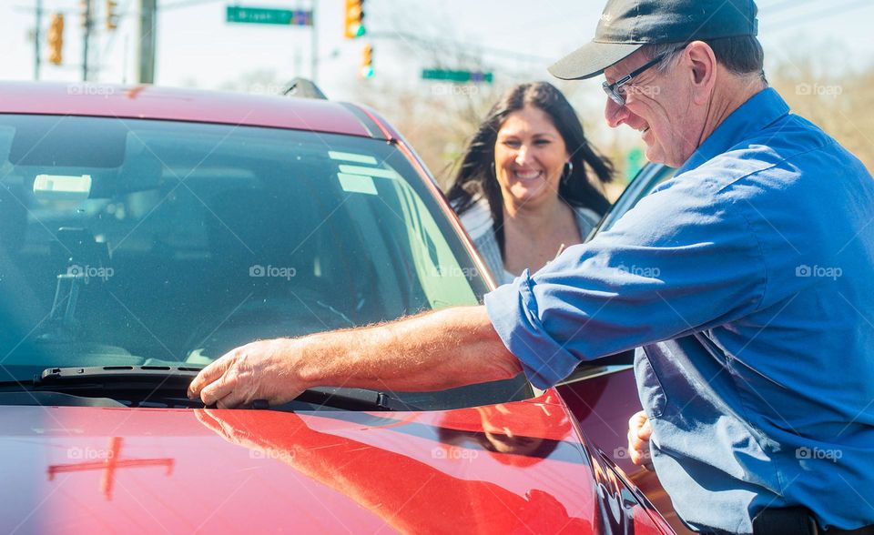 Selling used cars and checking windshield 