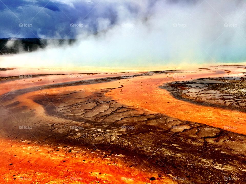 Bright orange and brown bands on S teaming Yellowstone thermal spring 