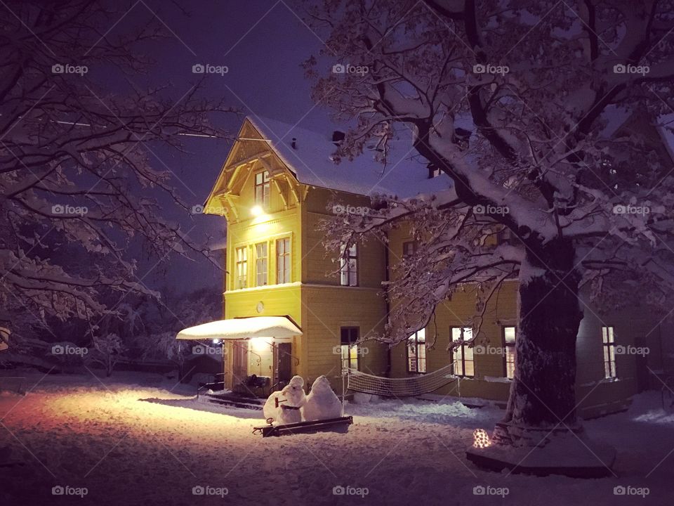 Old yellow school building covered in snow