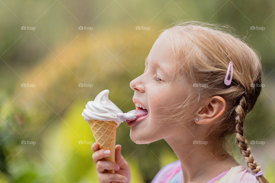 Happy kid eating ice cream at summer 