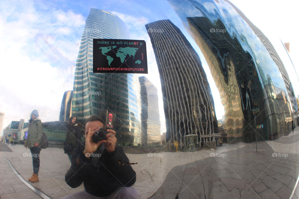 Photografer takes a Photo of him self and the neighborhood surrounding mirrored in a steel ball where everything is distorted.
This object is placed in tje middle of the Le Defence,Paris