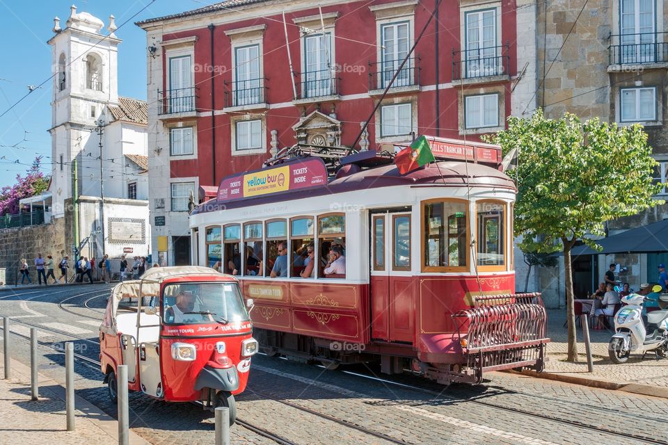 Tram 28 and a tuk-tuk at Portas do Sol, viewpoint,  Alfama, Lisbon, Portugal