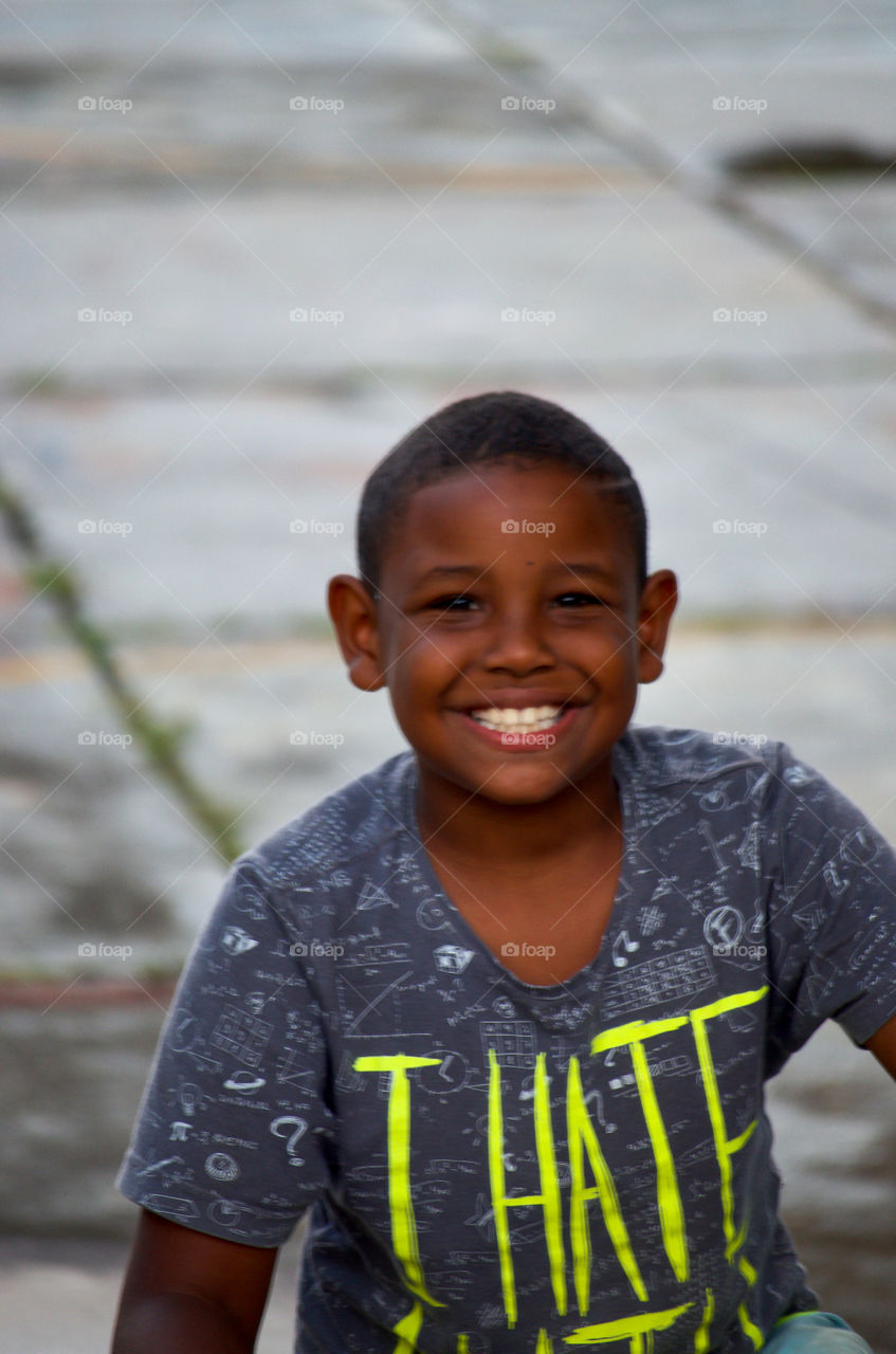 Boy smiling looking at camera. He lives in a little ivillage and he was curious and happy to take a picture. 