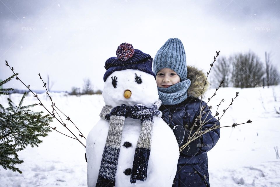 Portrait of a boy with a snowman.