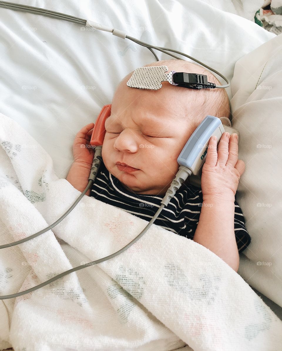 Newborn boy getting a sound hearing test in the hospital