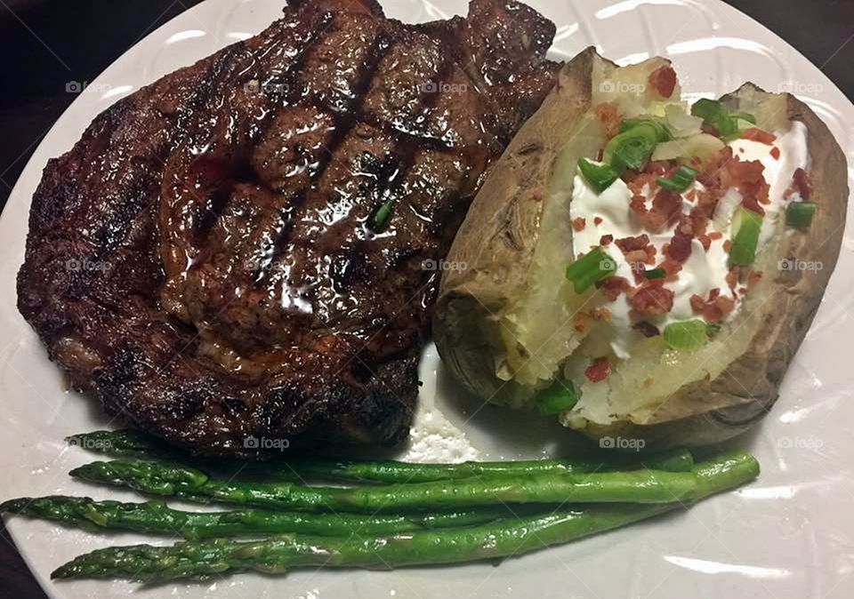 Grilled Ribeye Steak with potato and asparagus. 
