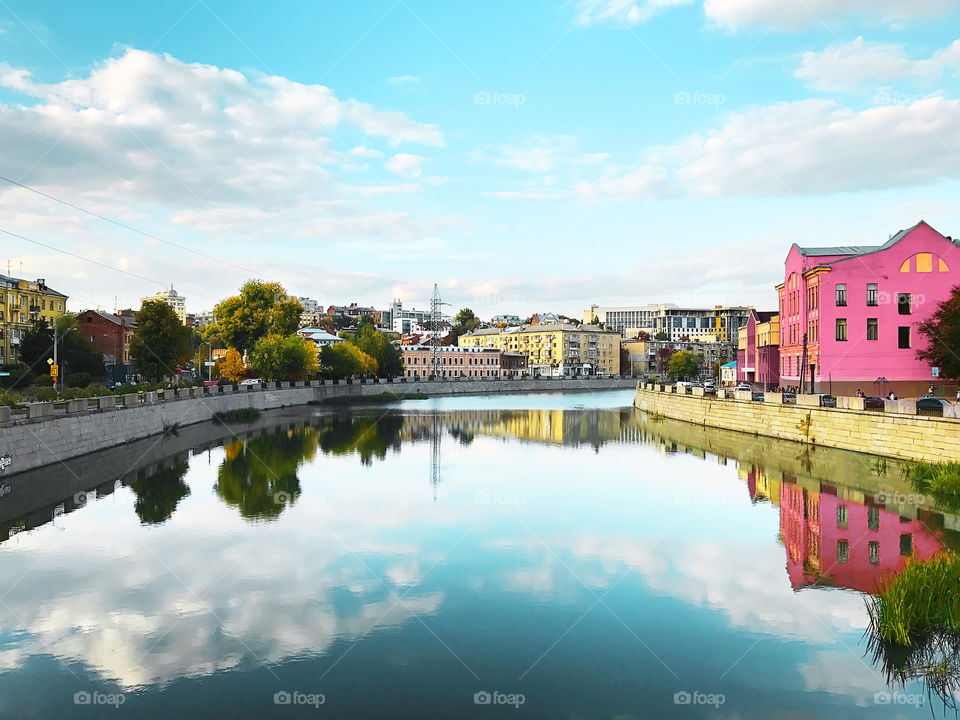 Beautiful cityscape with old buildings over the river with clouds reflection 