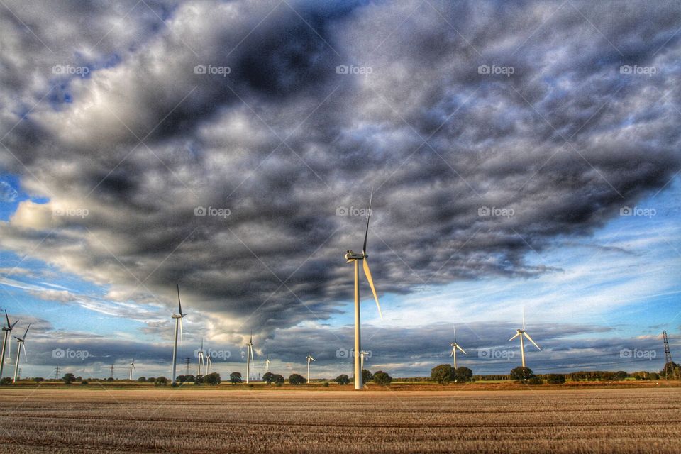 Wind power generators under a stormy sky.