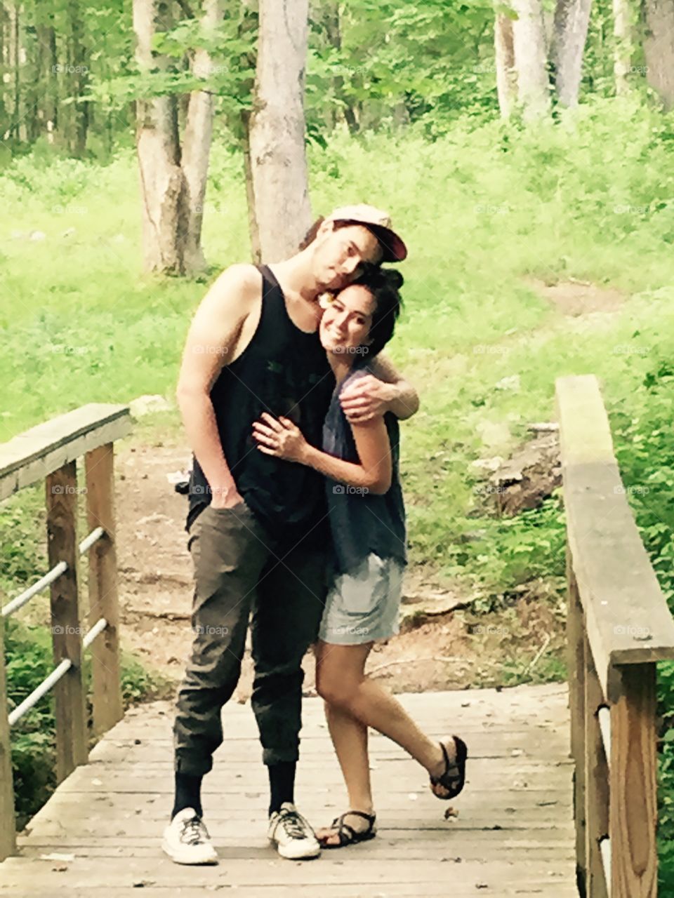 Couple hugging on bridge in park