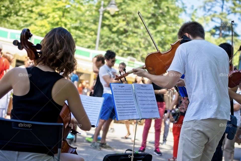 Young street musicians play in a park