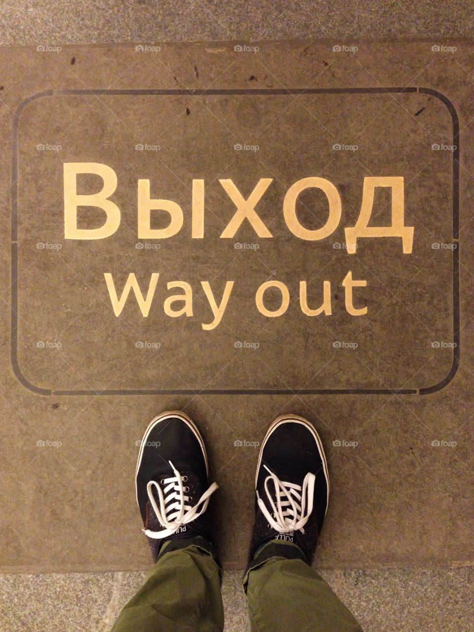 Blue shoes near the white way out выход sign