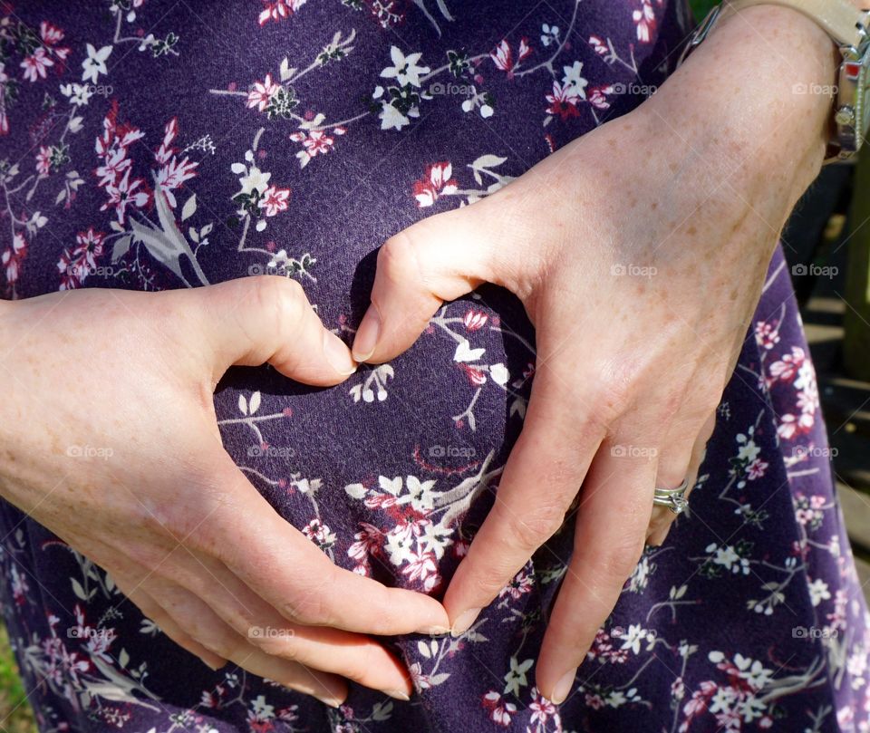 Feeling excitement for the new mum to be and clasping her hands in an affectionate way to express her love outwardly.