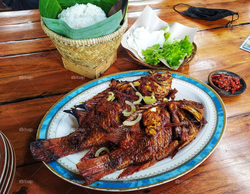 Today's menu is rice, grilled fish, fresh vegetables and sambal