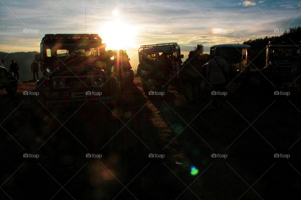 Sunrise that illuminates the car parking area on a hill in the Bromo mountains, East Java.