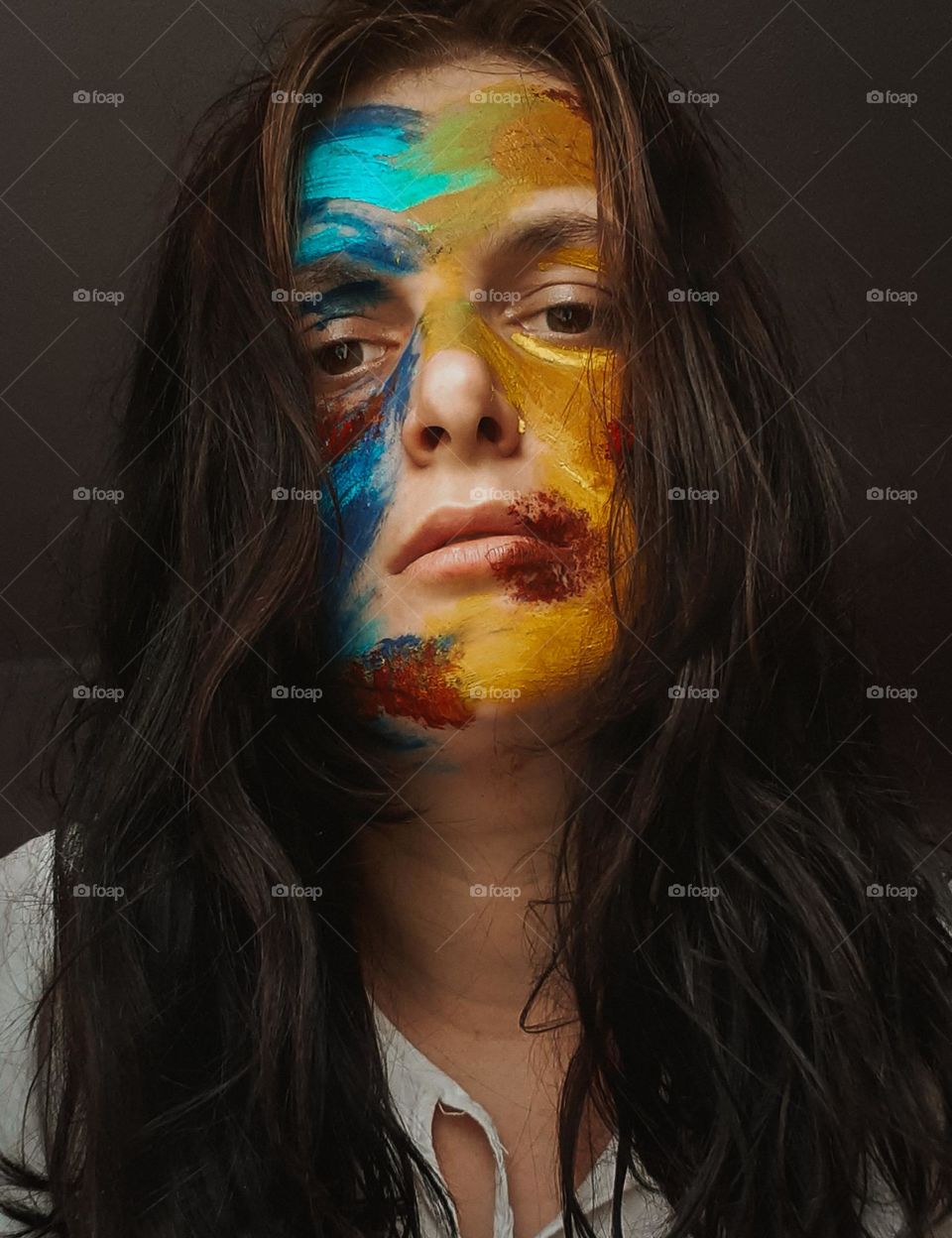conceptual portrait of a girl with face paint in the colors that form the flag of Ukraine and symbolize the fight for freedom