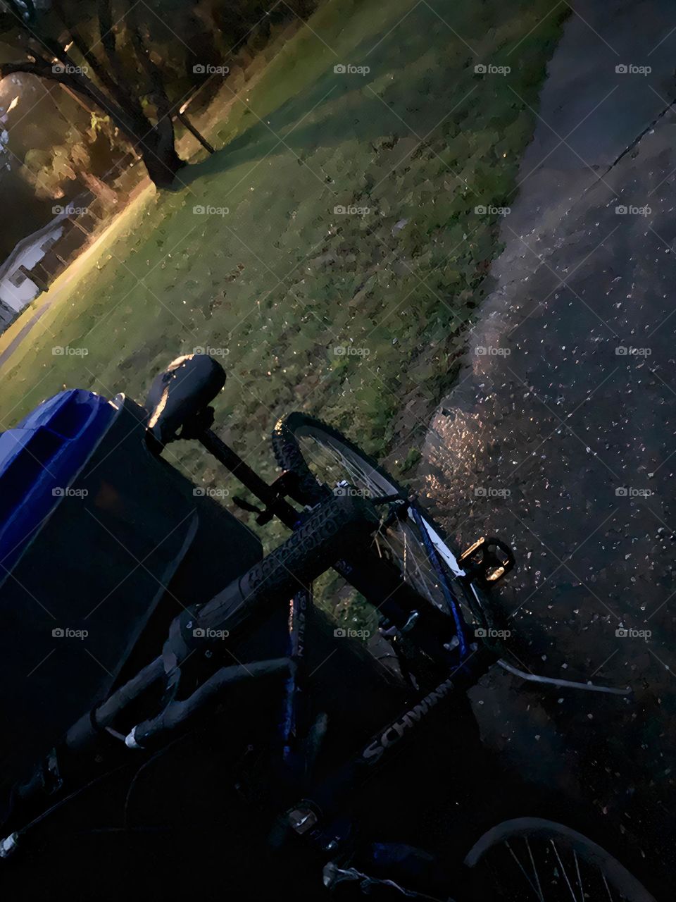 A Lonely Bicycle At Night Against A Recycle Bin Forgotten But Seen With The Street Light.