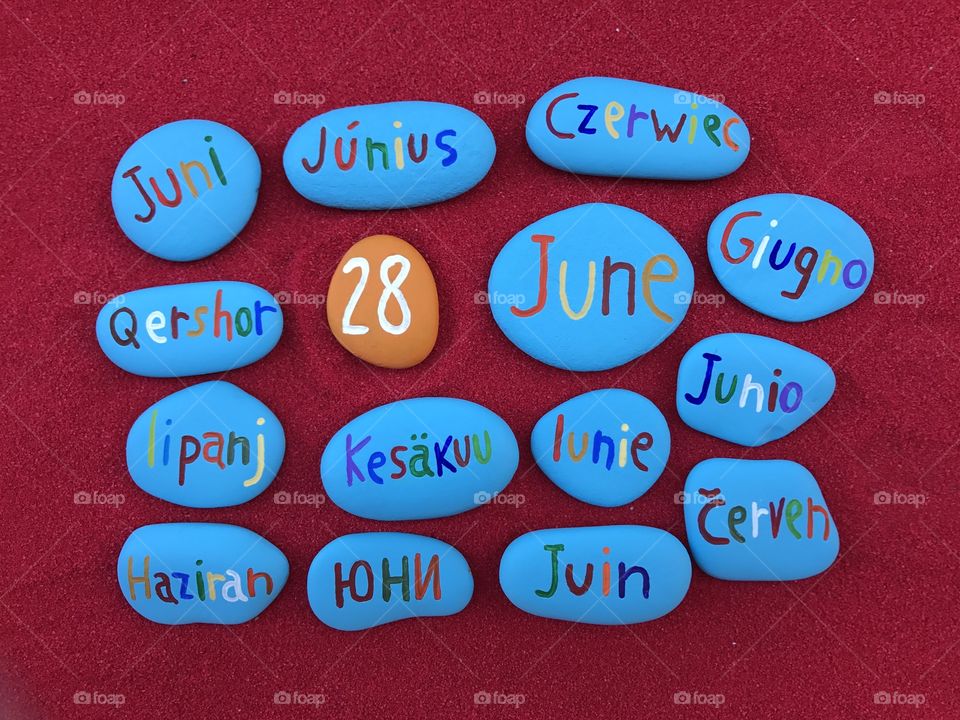 28 June, calendar date in many languages with colored stones and red background 